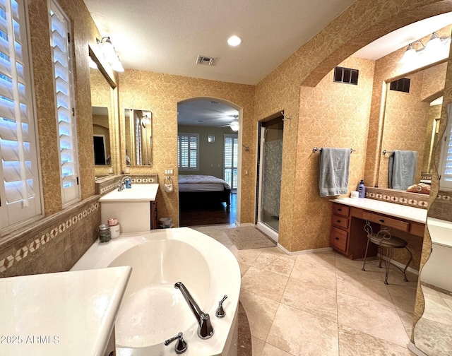 ensuite bathroom featuring visible vents, connected bathroom, a stall shower, and a garden tub