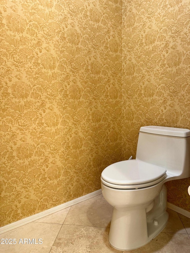 bathroom featuring tile patterned flooring, wallpapered walls, toilet, and baseboards