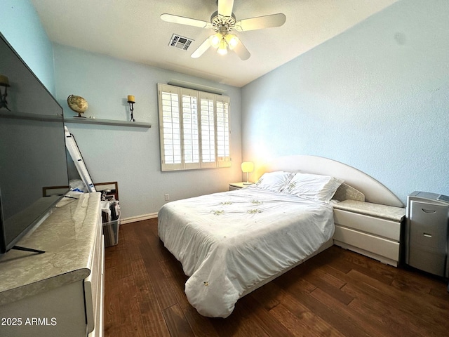 bedroom with a ceiling fan, dark wood-style floors, visible vents, and baseboards