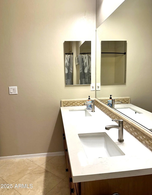 full bathroom with a sink, baseboards, double vanity, and tile patterned flooring