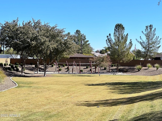 view of home's community with a lawn and fence