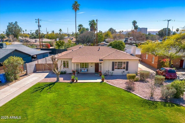 view of front of property featuring a shingled roof, a front yard, concrete driveway, and fence