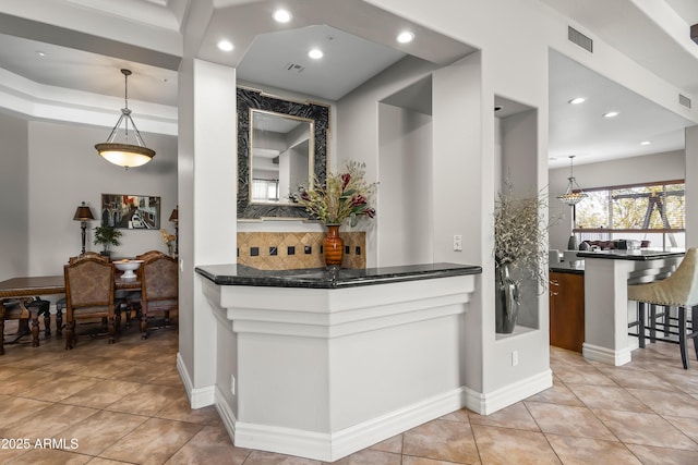 kitchen featuring visible vents, backsplash, a breakfast bar, light tile patterned floors, and recessed lighting