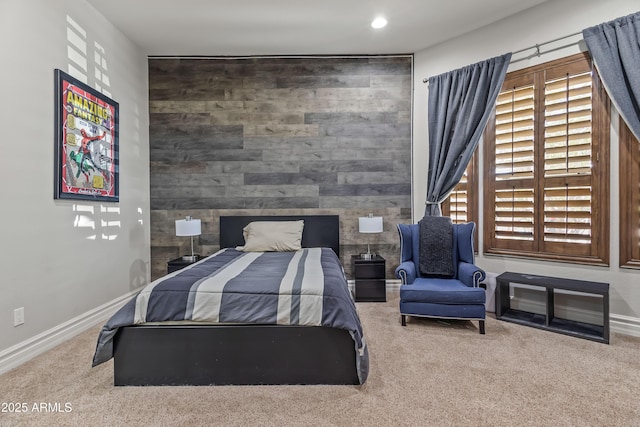 carpeted bedroom with an accent wall, recessed lighting, and baseboards