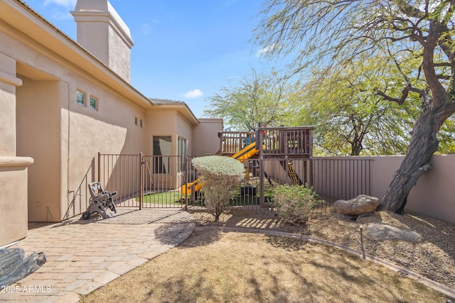 view of yard with a patio area, a playground, and fence