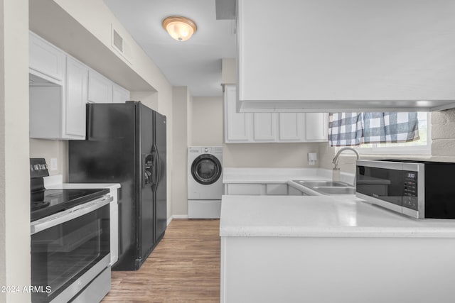 kitchen with stainless steel appliances, white cabinets, sink, light hardwood / wood-style flooring, and washer / dryer