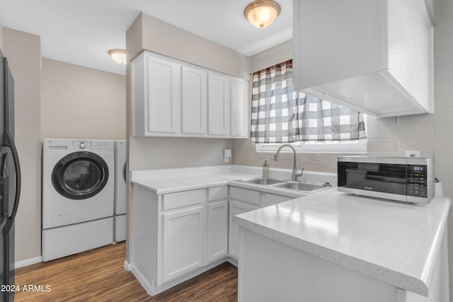 laundry area featuring dark wood-type flooring, sink, and separate washer and dryer