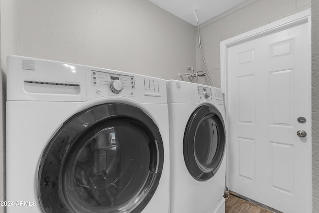 laundry area with hardwood / wood-style floors and washing machine and dryer