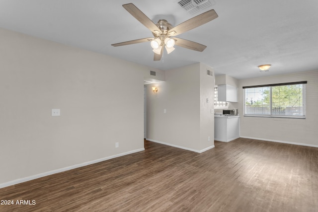 unfurnished living room with dark hardwood / wood-style flooring and ceiling fan