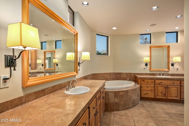 bathroom with a relaxing tiled tub, tile patterned floors, and vanity