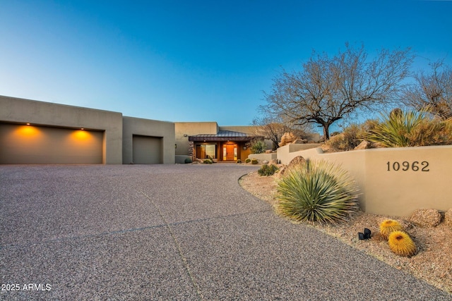 pueblo revival-style home featuring a garage