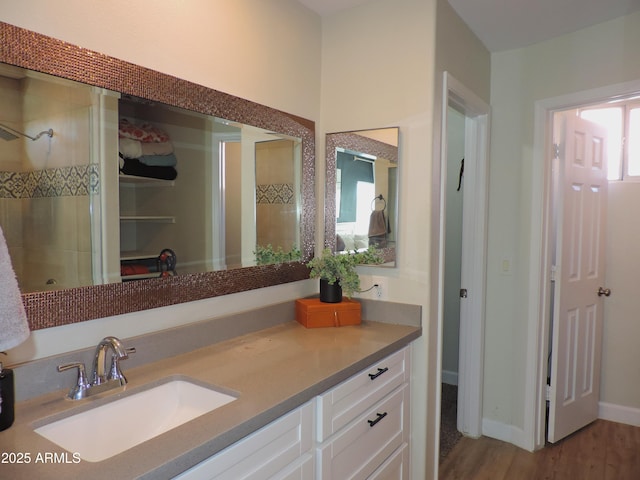 bathroom featuring hardwood / wood-style floors, vanity, and walk in shower