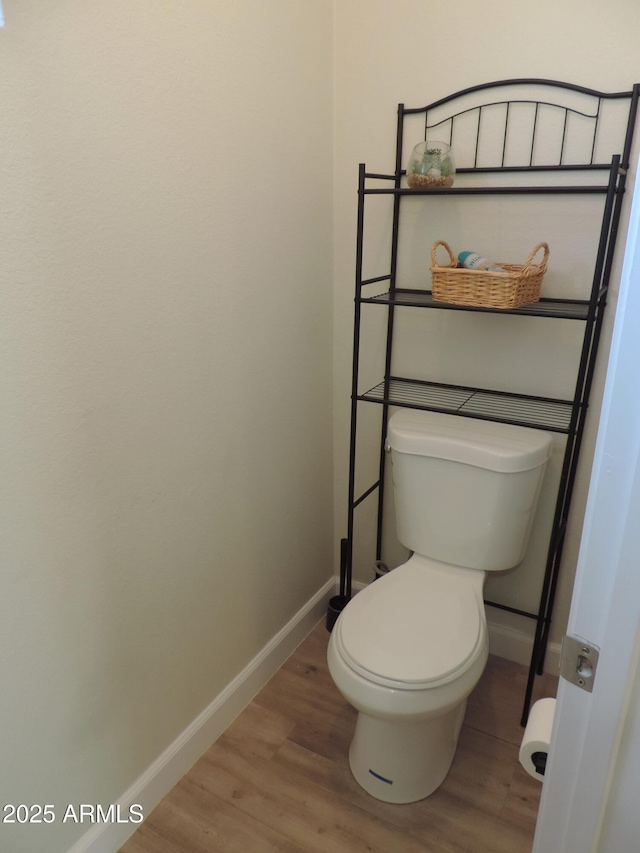 bathroom featuring wood-type flooring and toilet