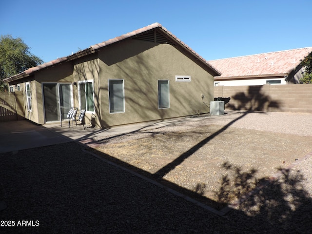 rear view of house featuring cooling unit and a patio