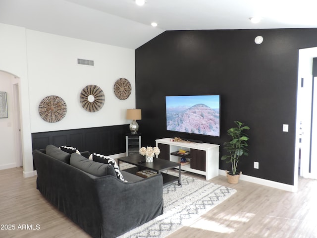 living room featuring light hardwood / wood-style floors and vaulted ceiling