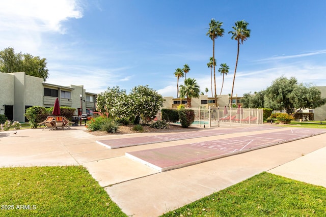 view of community with shuffleboard and fence