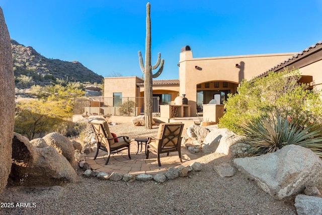 view of patio with fence and a mountain view