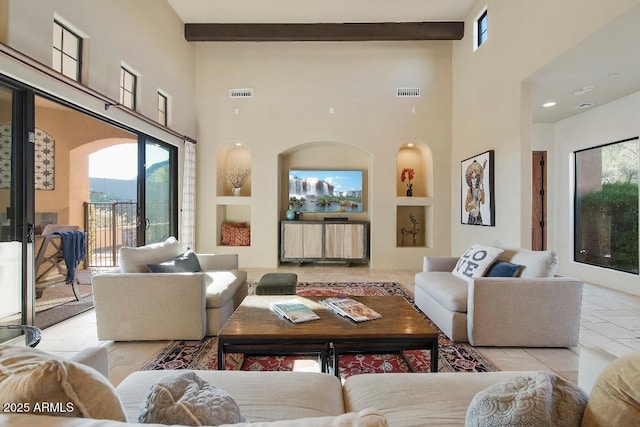 living room with a high ceiling, built in shelves, and beamed ceiling