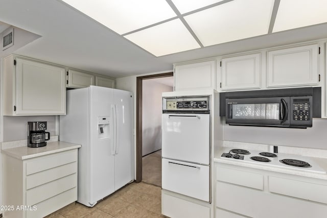 kitchen with light tile patterned flooring, white appliances, visible vents, white cabinets, and light countertops