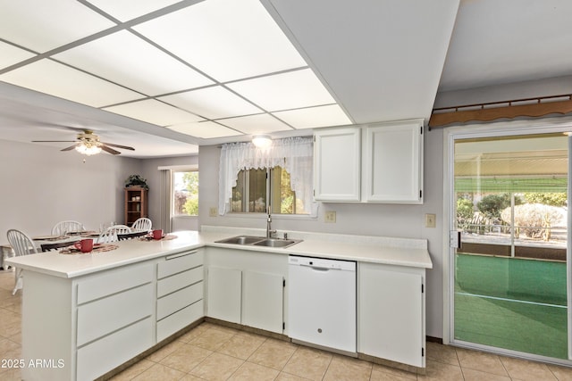 kitchen with light countertops, white cabinetry, white dishwasher, a sink, and a peninsula