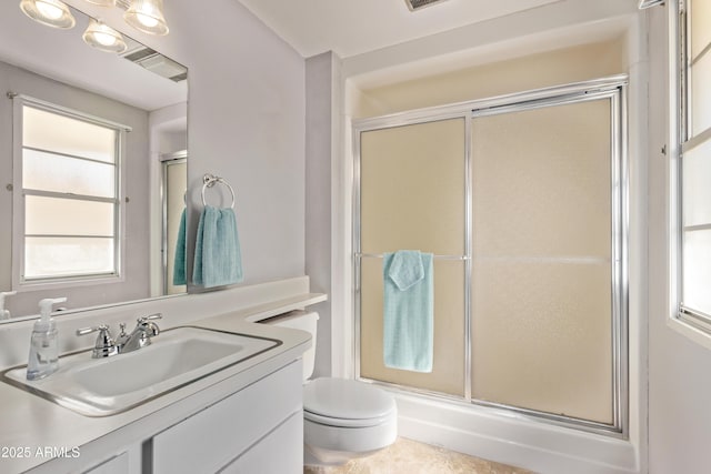 bathroom featuring vanity, a shower stall, and toilet