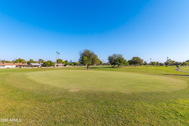 view of community with view of golf course and a yard