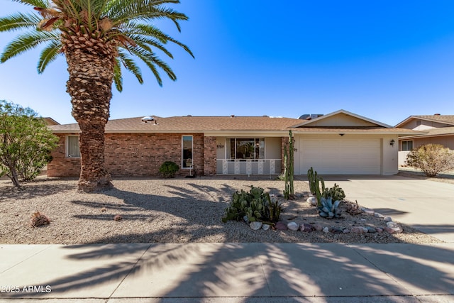 ranch-style house featuring a garage, concrete driveway, and brick siding