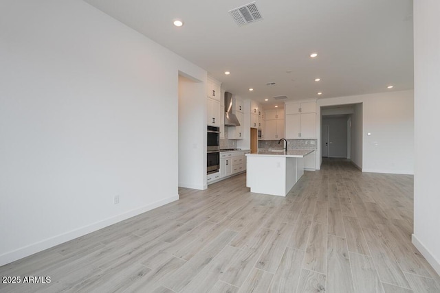 1246 E Penedes Dr, Gilbert, AZ 85298 - kitchen with open floor plan, white cabinets, baseboards, light wood finished floors, and recessed lighting
