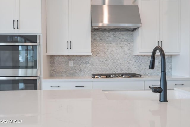 1246 E Penedes Dr, Gilbert, AZ 85298 - kitchen with wall chimney range hood, stainless steel appliances, decorative backsplash, and white cabinets