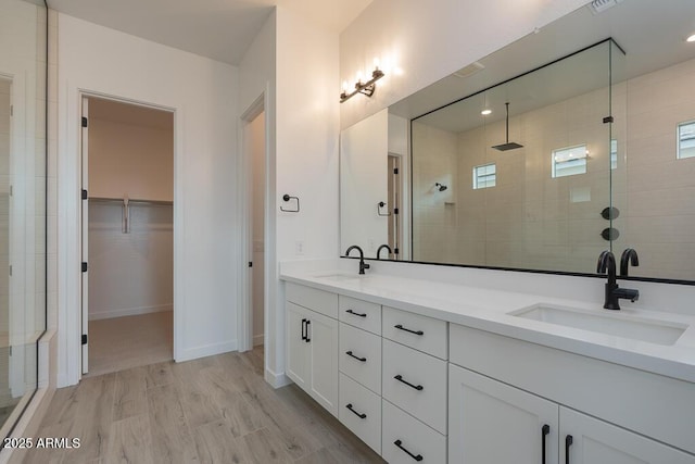 1246 E Penedes Dr, Gilbert, AZ 85298 - bathroom with a shower stall, a walk in closet, double vanity, and baseboards