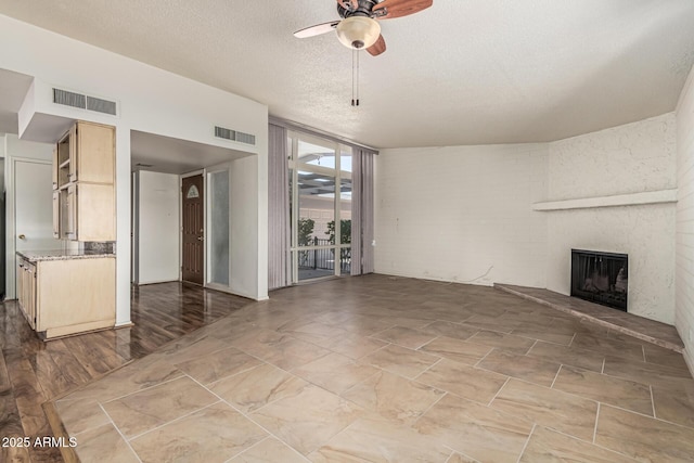 5420 N Granite Reef Rd, Scottsdale, AZ 85250 - unfurnished living room featuring ceiling fan, a wall of windows, a fireplace, and a textured ceiling