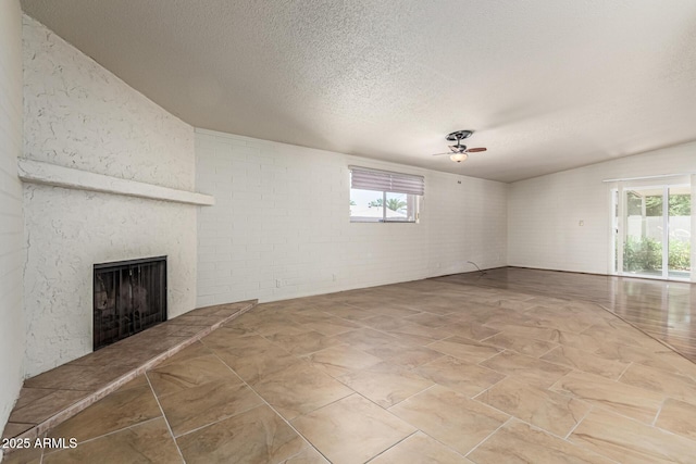 5420 N Granite Reef Rd, Scottsdale, AZ 85250 - unfurnished living room with a large fireplace, ceiling fan, and a textured ceiling