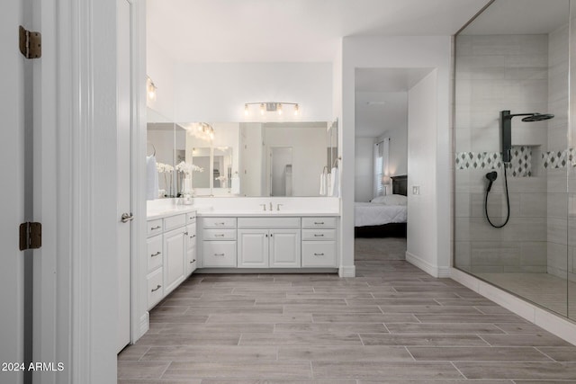 bathroom with a tile shower and vanity