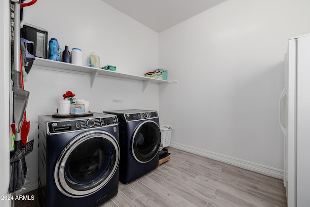 laundry room featuring washer and clothes dryer and light hardwood / wood-style floors