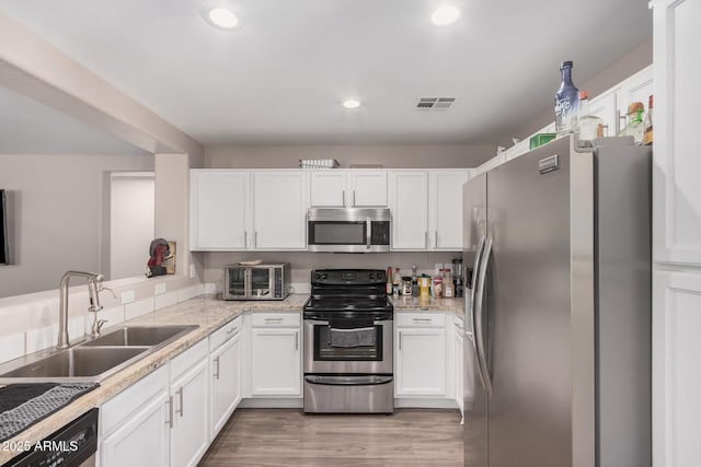 2516 E San Manuel Rd, San Tan Valley, AZ 85143 - kitchen with stainless steel appliances, white cabinets, light wood-type flooring, recessed lighting, and light stone countertops