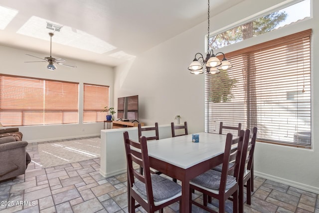 dining room with stone finish floor, visible vents, baseboards, and ceiling fan with notable chandelier