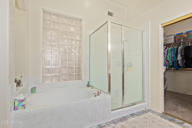full bathroom with visible vents, a spacious closet, a shower stall, and a garden tub