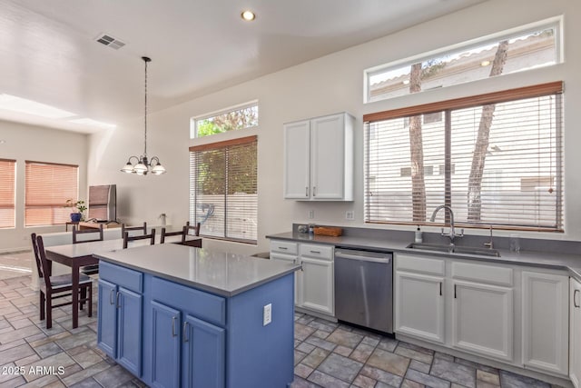 kitchen with a sink, white cabinets, stone finish floor, and dishwasher