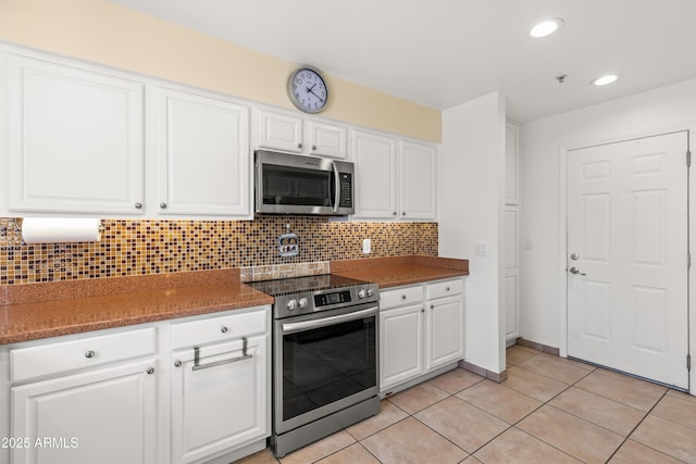 kitchen with white cabinetry, appliances with stainless steel finishes, light tile patterned flooring, and decorative backsplash