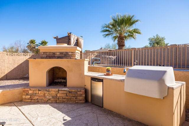 view of patio / terrace with area for grilling and an outdoor fireplace