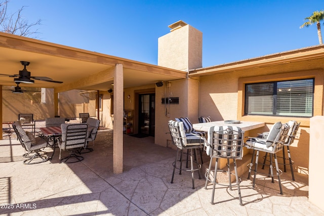 view of patio / terrace featuring a bar and ceiling fan