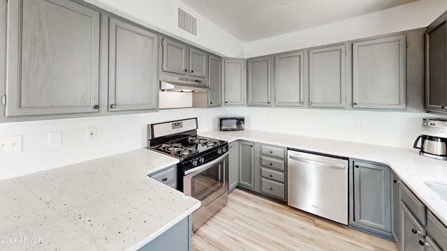 kitchen with stainless steel appliances, gray cabinets, and light wood-type flooring