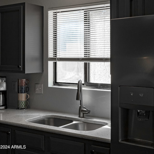 kitchen featuring sink and light stone countertops