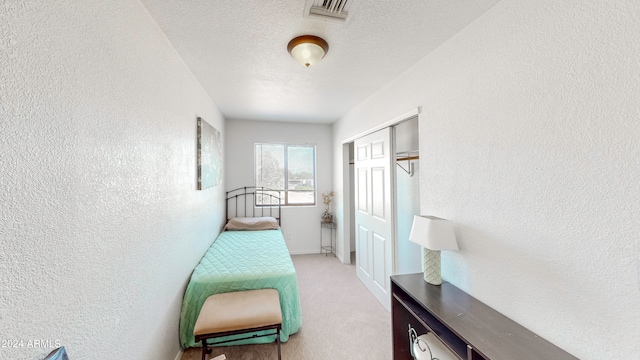 hall featuring a textured ceiling and light carpet