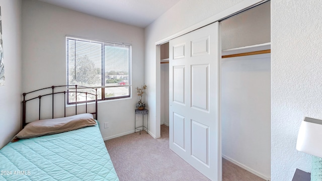 bedroom featuring light carpet and a closet