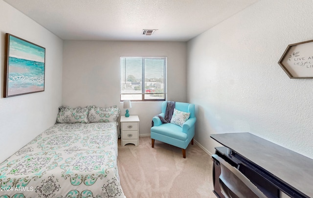 bedroom with a textured ceiling and light carpet