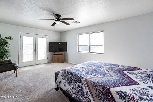 carpeted bedroom featuring multiple windows, a textured ceiling, ceiling fan, and access to exterior