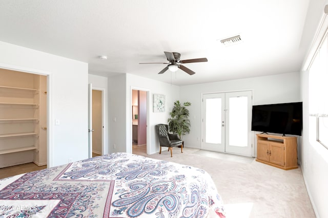 bedroom featuring a spacious closet, ceiling fan, multiple windows, and french doors