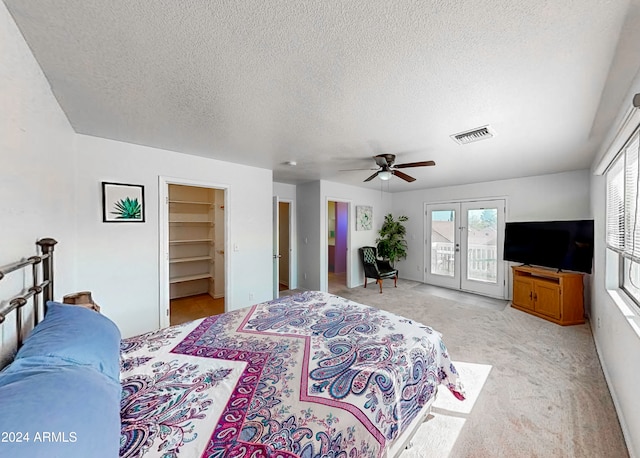 carpeted bedroom featuring access to exterior, a textured ceiling, ceiling fan, a closet, and a spacious closet