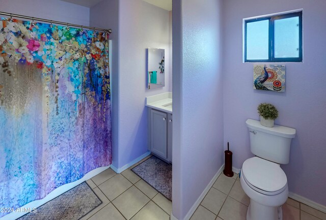 bathroom with a shower with shower curtain, vanity, tile patterned floors, and toilet